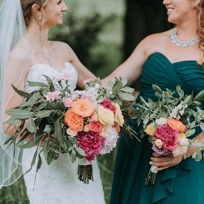 bride holding bouquet of assorted-color flowers standing on grass field