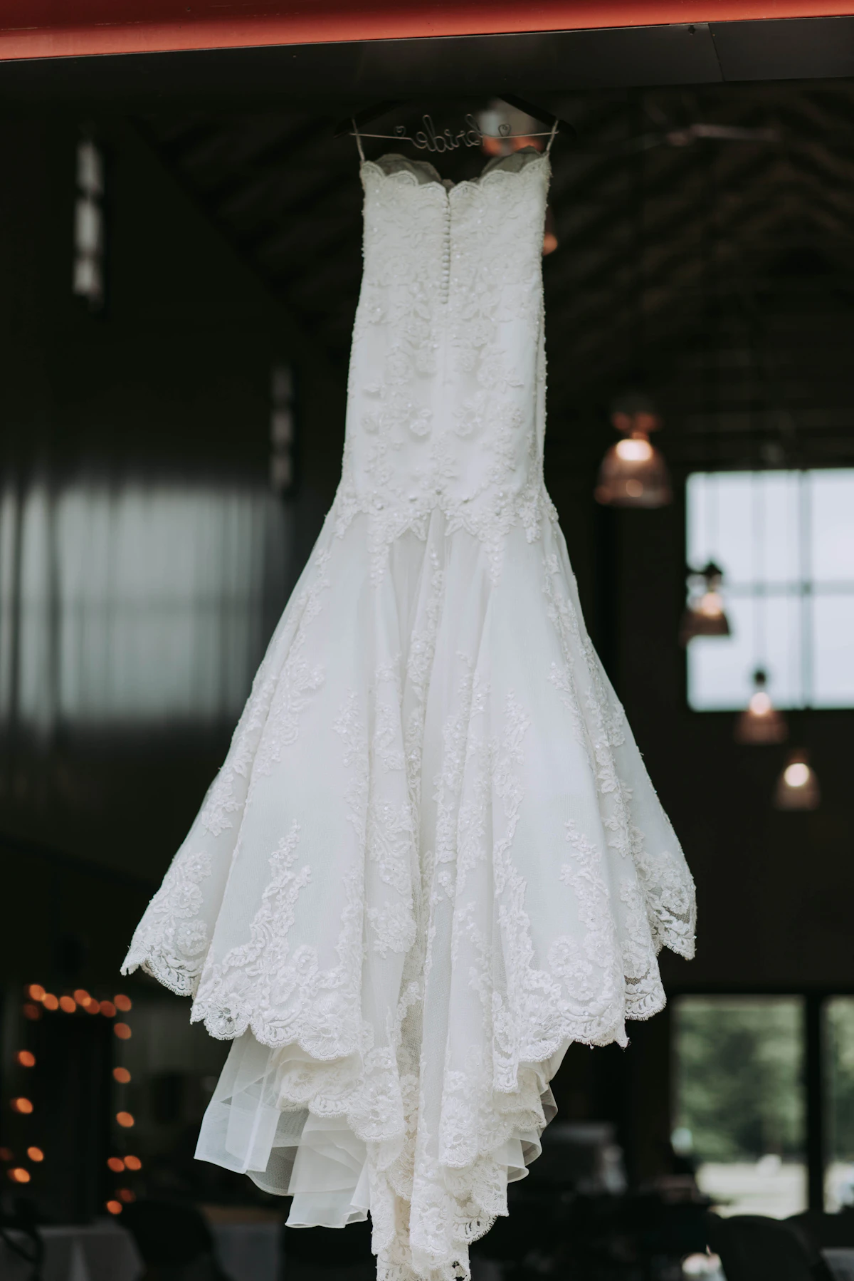 Lace wedding dress hanging up before the ceremony