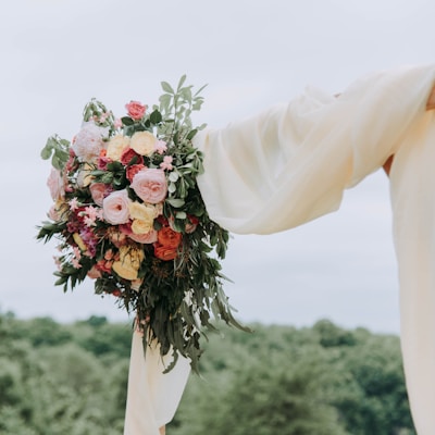 bouquet of assorted-color flowers hanged on brown plank with white textile