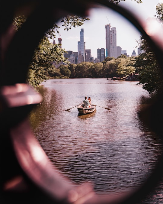 man and woman riding on gray wooden boat in Central Park United States
