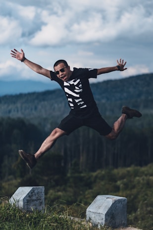 A man joyfully jumping in the air outdoors, representing financial freedom with credit cards.