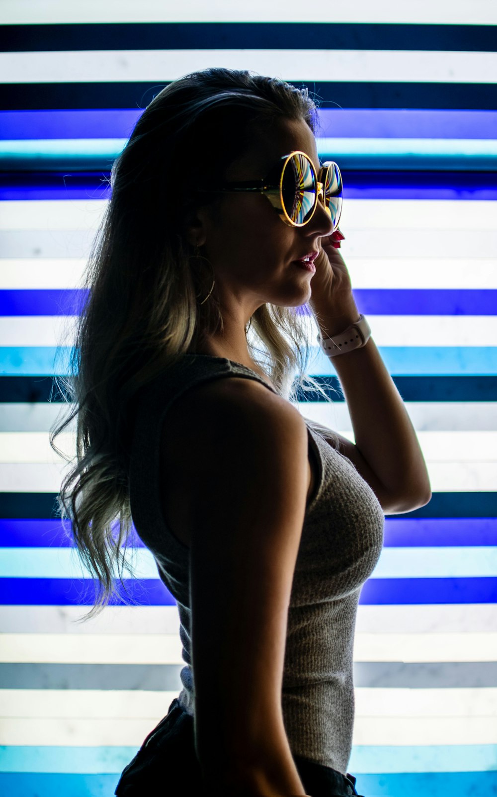 woman wearing gray tank top standing on LED wall