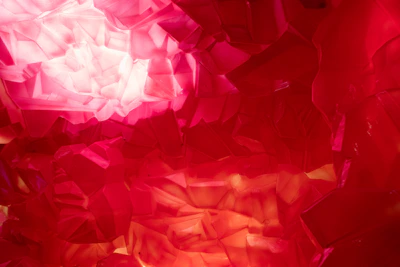 A close-up of a glowing, multicolored crystal against a black background.
