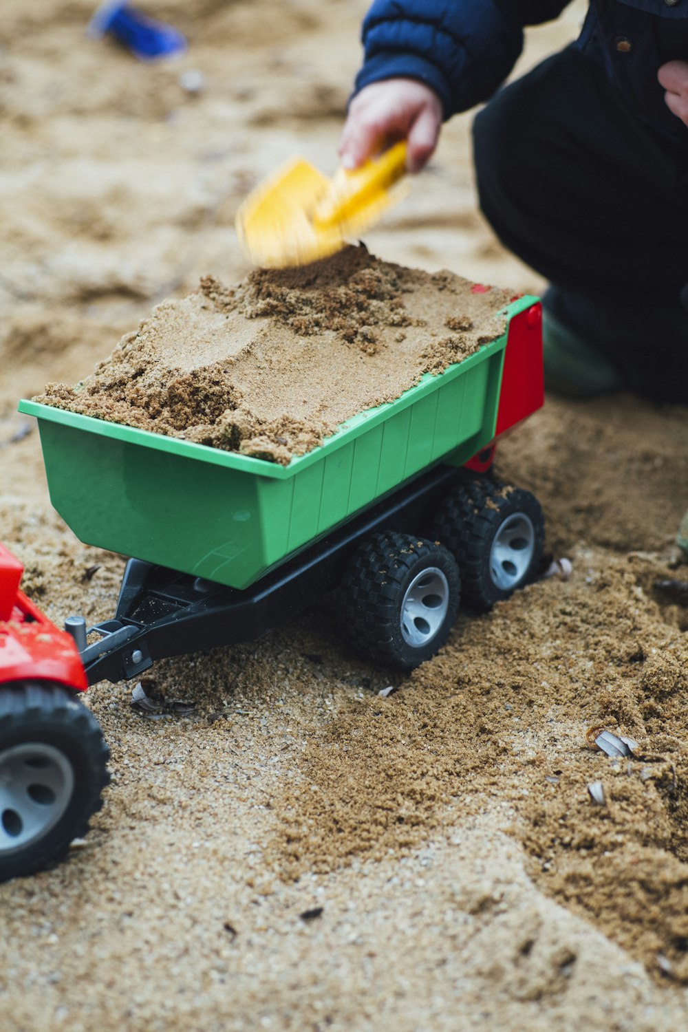 茶色の砂でいっぱいのおもちゃのトレーラーのセレクティブフォーカス写真