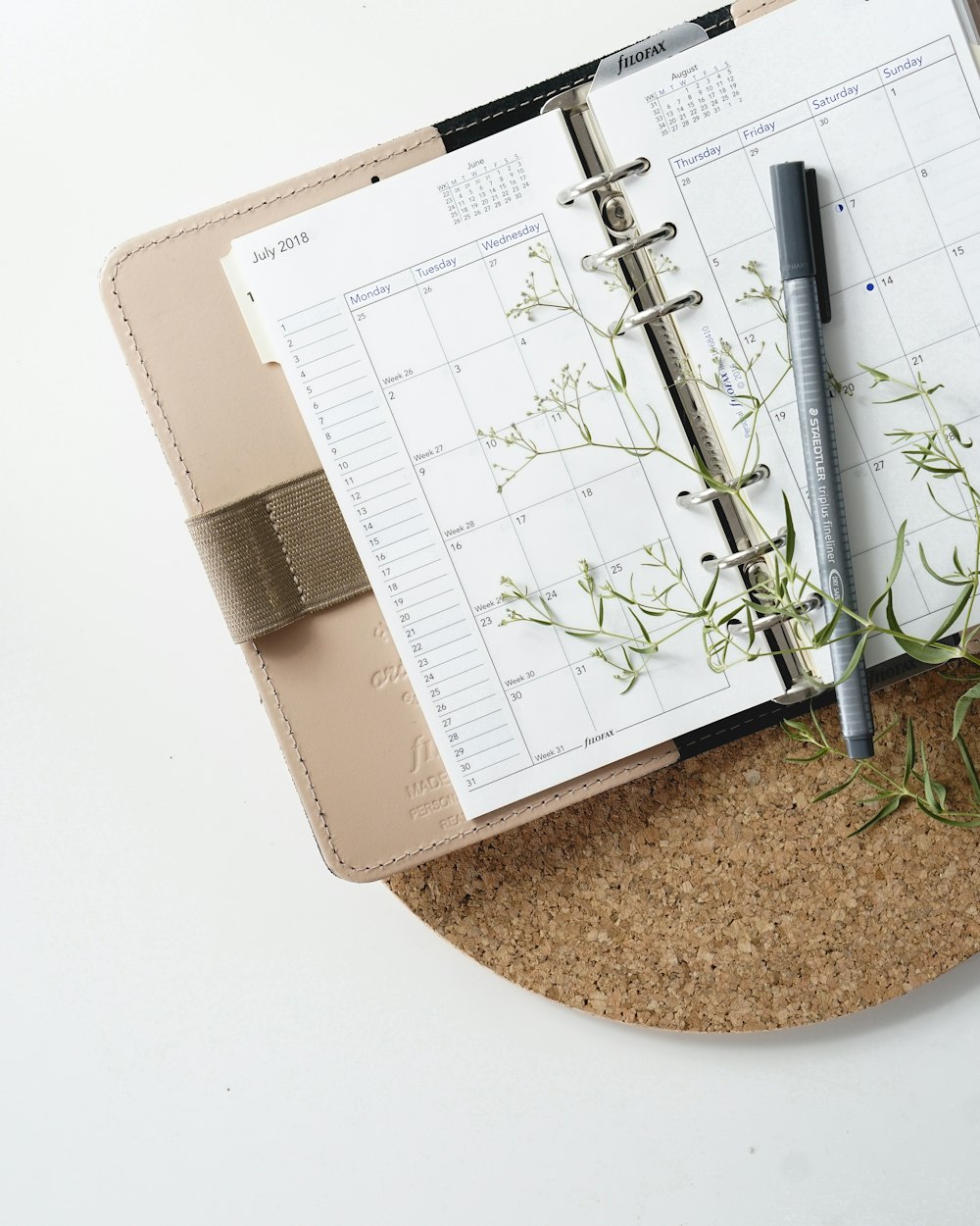 grey and black pen on calendar book