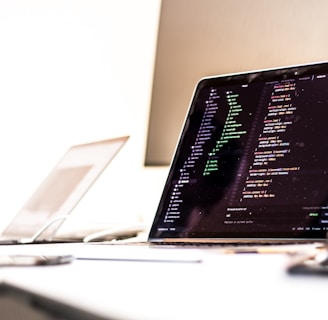 black laptop computer turned-on displaying source code on table