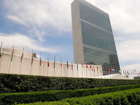 A sleek office building with international flags fluttering, symbolizing global work opportunities.