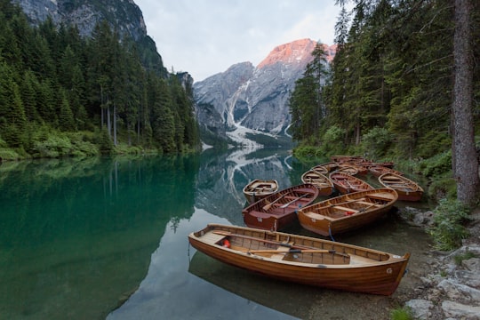 brown wooden jon boat on the body of water in Parco naturale di Fanes-Sennes-Braies Italy