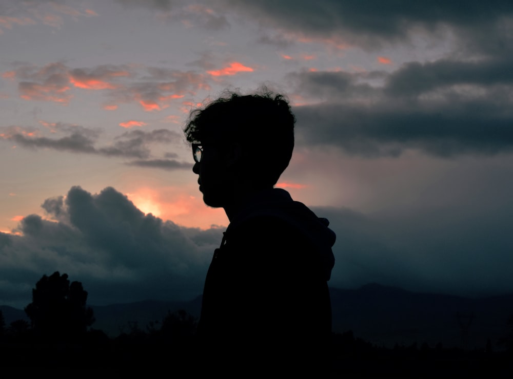 silhouette photography of man standing near trees