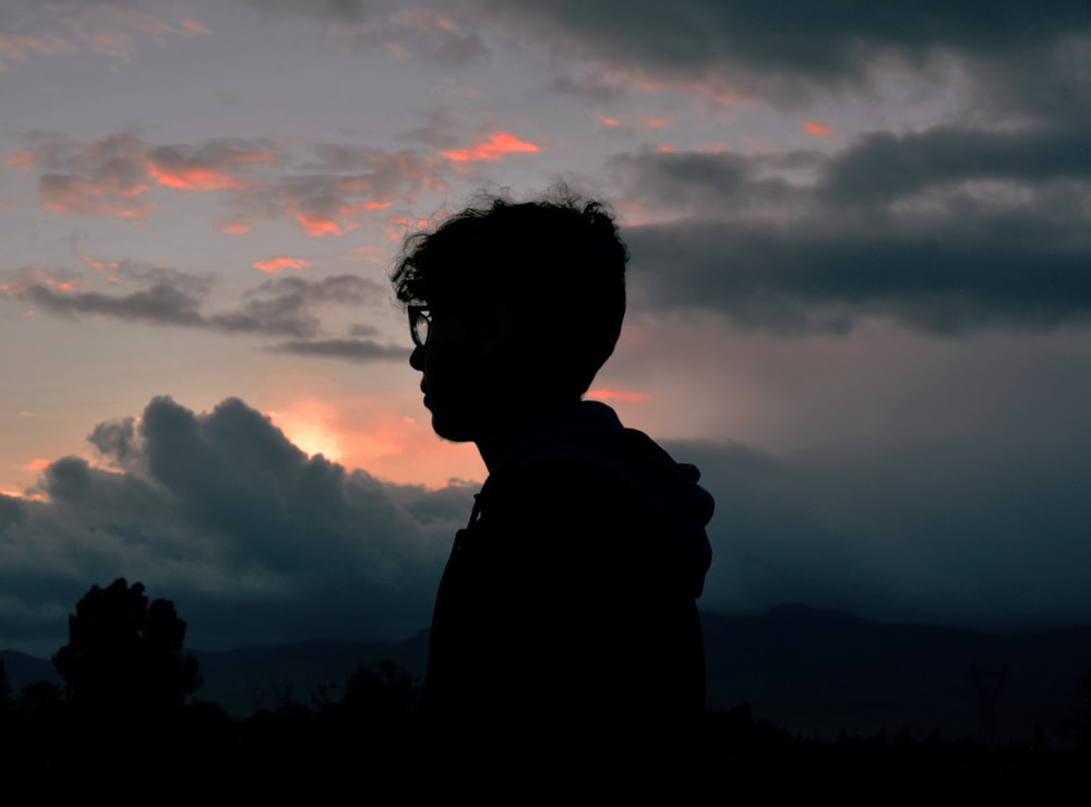 Fotografía de la silueta del hombre de pie cerca de los árboles