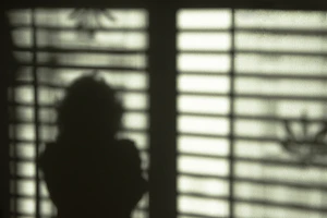 Artistic shot of clothing silhouettes casting gentle shadows on a textured wall