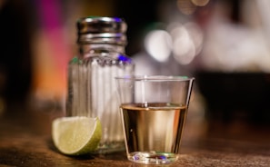 clear glass cup beside sliced lime on brown surface