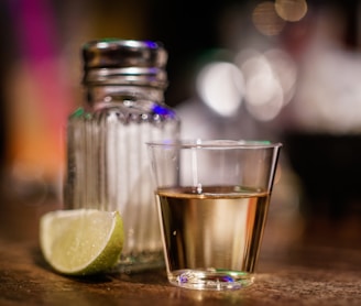 clear glass cup beside sliced lime on brown surface