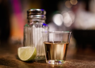 clear glass cup beside sliced lime on brown surface