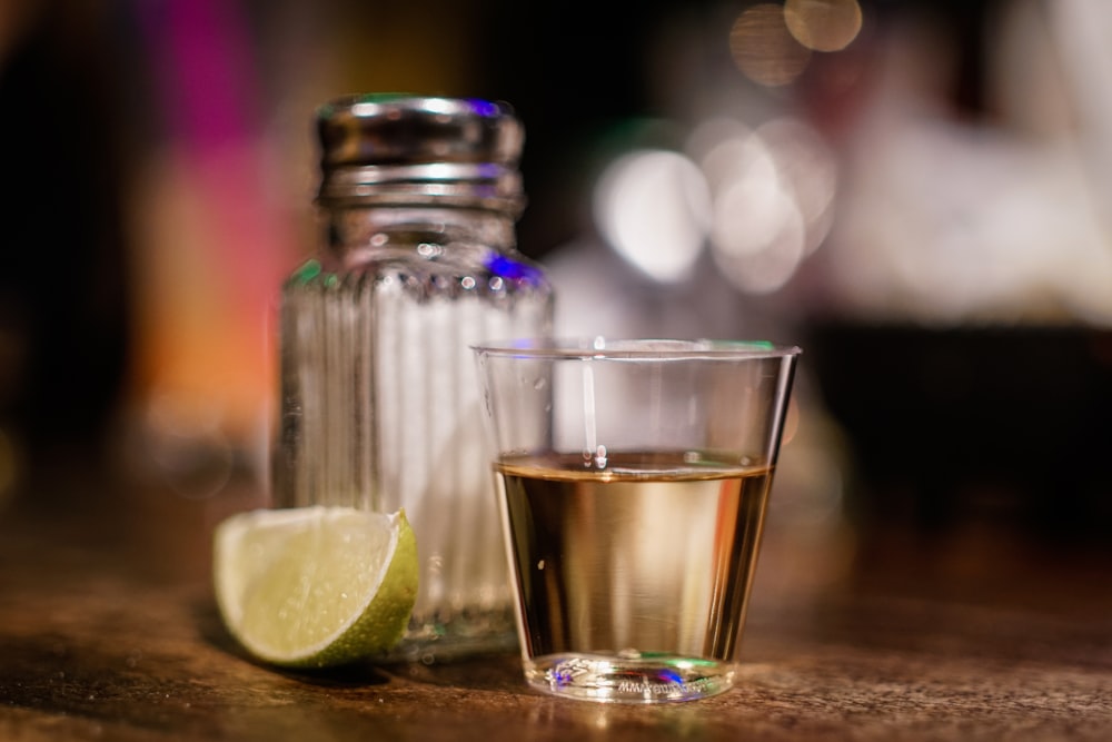 clear glass cup beside sliced lime on brown surface