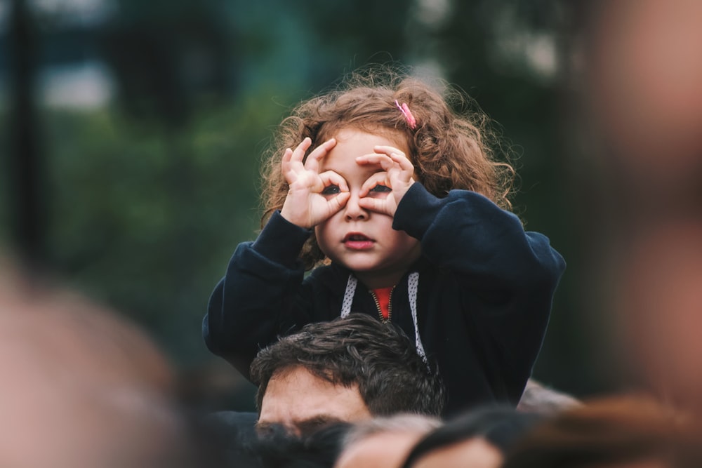 girl making hand gesture on her face