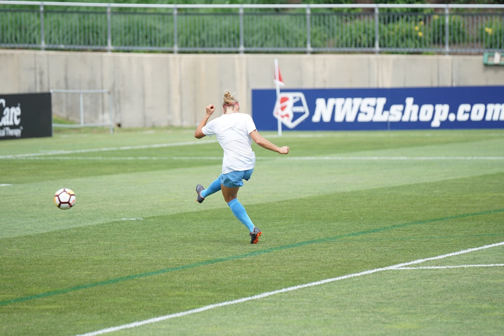 Frau kickte Fußball auf dem Fußballplatz