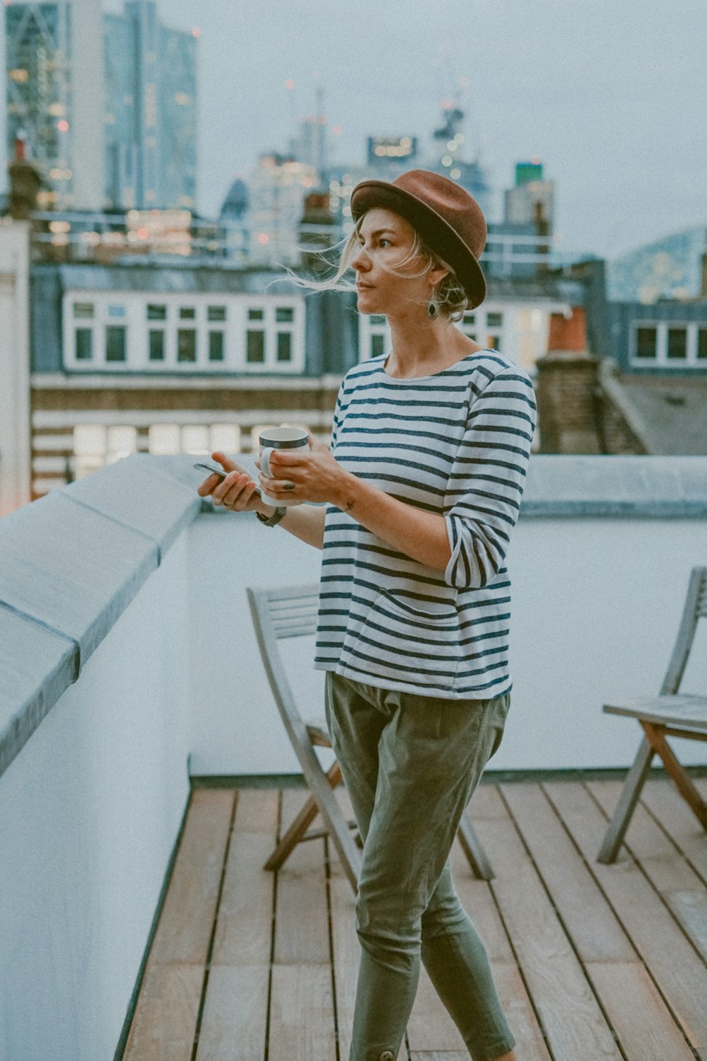 woman in white and black striped shirt holding mug