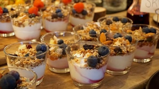 Three vibrant frozen yogurt cups with fresh fruit toppings arranged playfully.