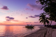Sunset view over the Cancun coastline with boats anchored near the reef.
