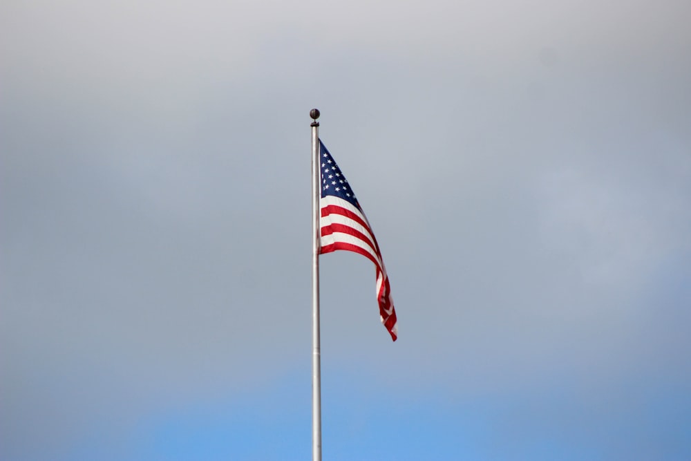 waving US flag under grey cloudy sky