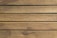 Wooden planks aligned horizontally, exhibiting natural textures and grain patterns, with a weathered and slightly rustic appearance.