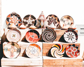 Close-up of traditional Arhuaca crafts displayed on a wooden table with vibrant colors.
