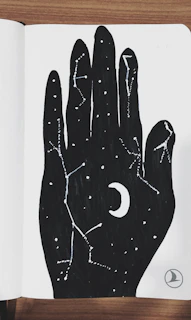 A laptop sleeve decorated with a mystical moon phases illustration in black and white