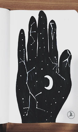 A minimalist white notebook with a black crescent moon and stars design representing esoteric themes.