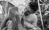 A couple sharing a playful moment in a park.