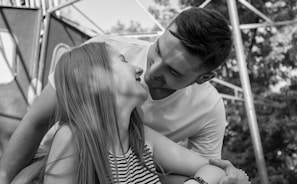 A candid shot of a couple sharing a playful moment outdoors.