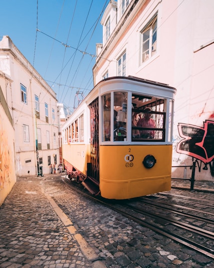yellow and white tram climbing up hill