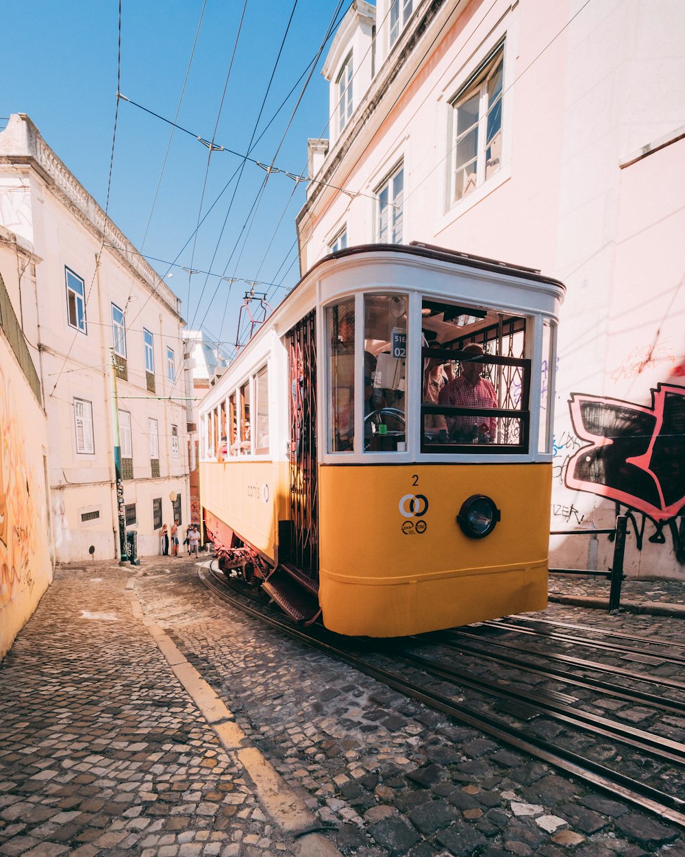 Tram jaune et blanc qui monte la colline