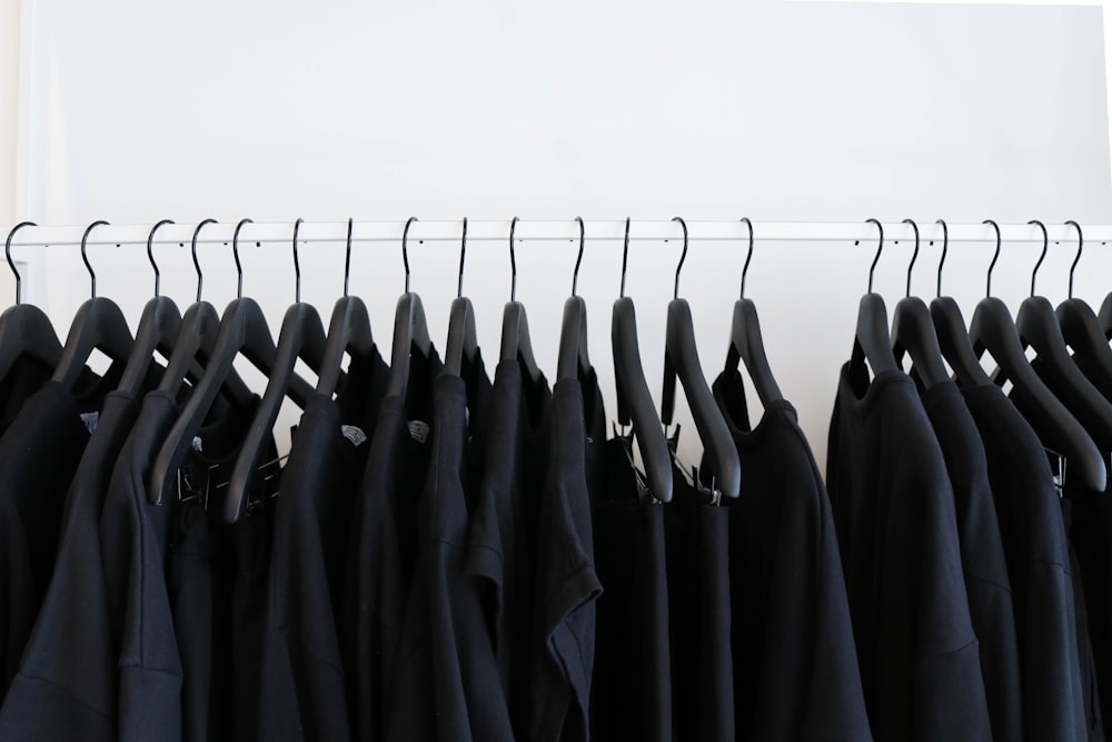 roupas pretas penduradas em rack