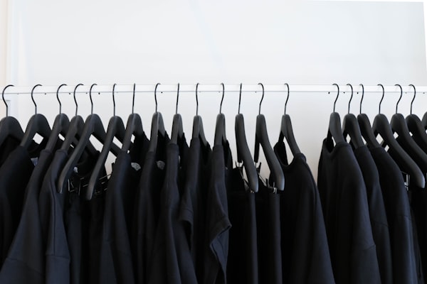 A clothes rack of black t-shirts