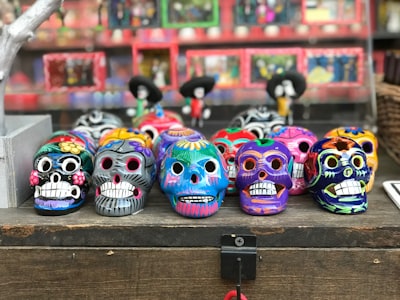 multi-colored sugar skull figurines mariachi teams background