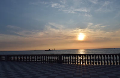 A stunning sunset view over a luxury villa terrace with golden lights glowing warmly.