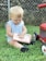 toddler sitting on grass during day