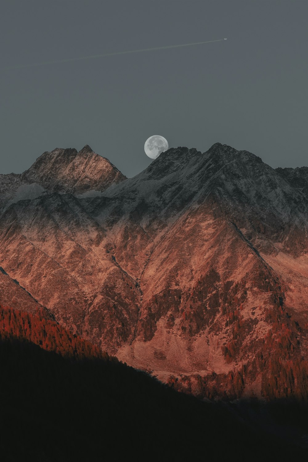 full moon hiding on mountain
