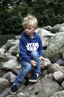 boy seating on rock fragments