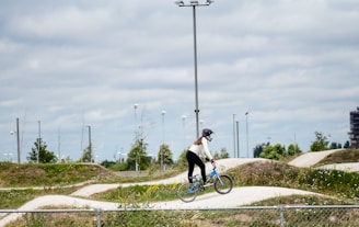 A dynamic shot of Alexandre riding his BMX on a race track with a dark background.