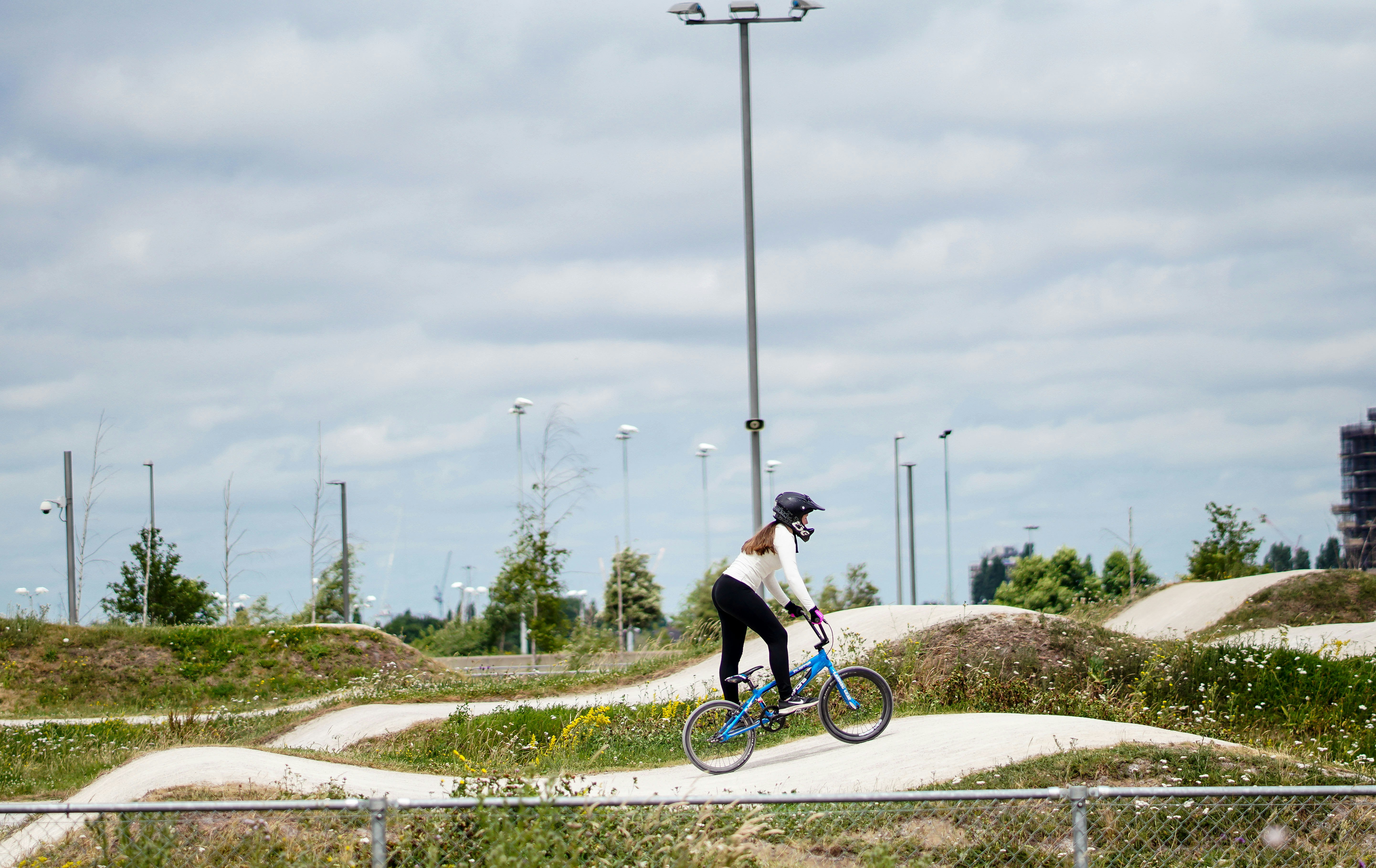 person riding blue bicycle on white pathway