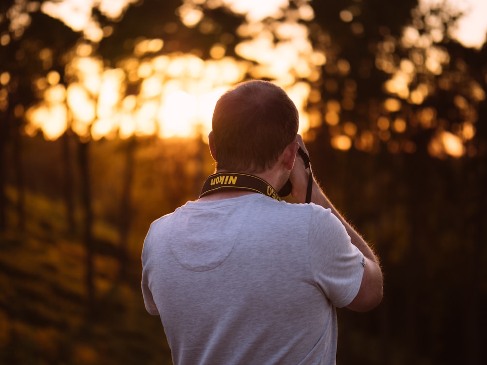 person taking picture of trees