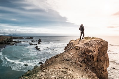 man on edge of cliff brave teams background