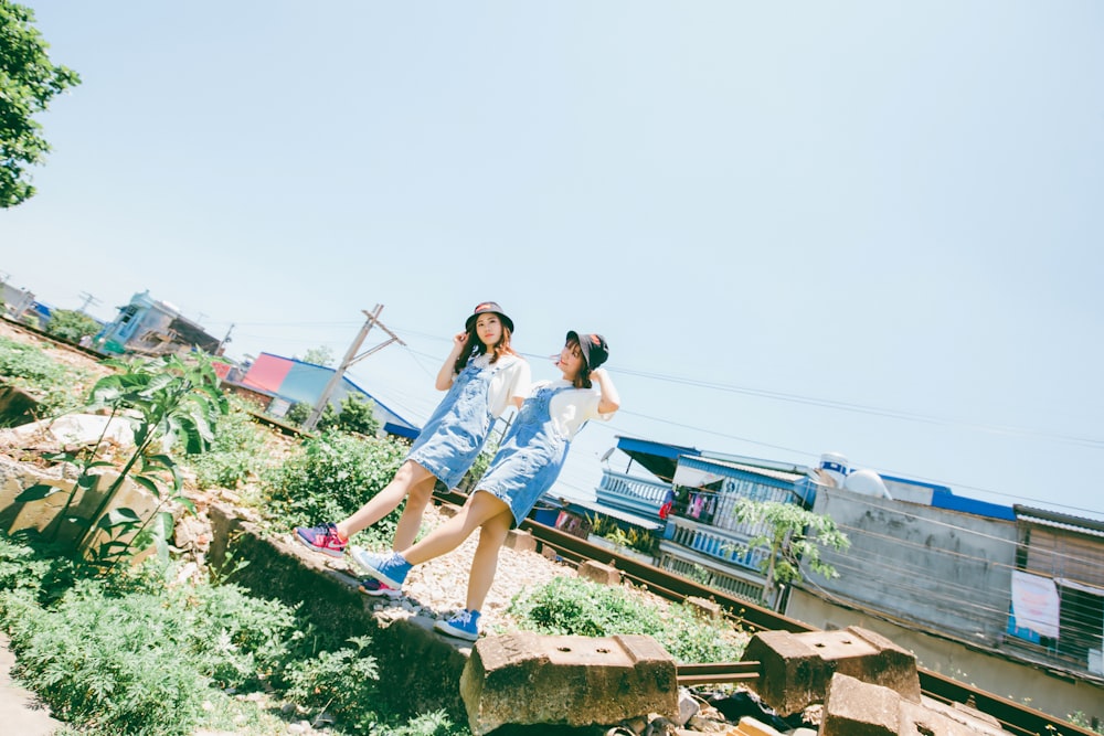 two girls walking on grass area