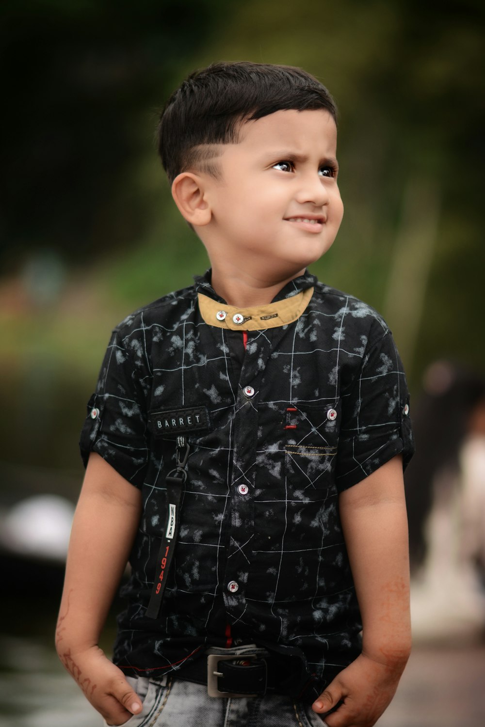 boy standing holding his pocket during daytime