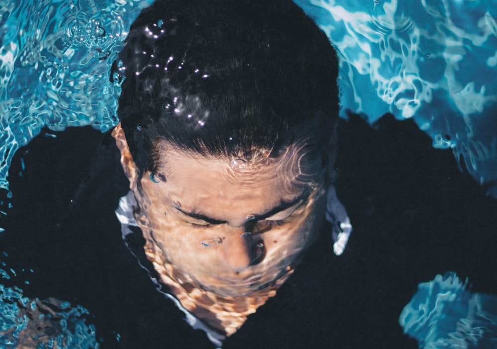 man in blue top underwater during daytime