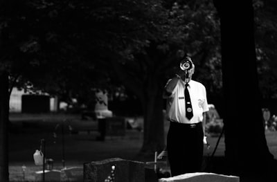 grayscale photo of man wearing dress shirt and necktie grieving teams background