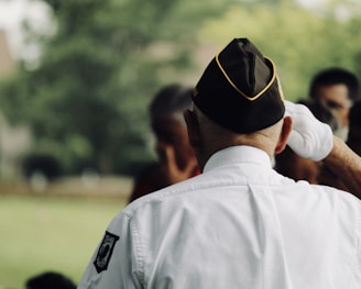 man wearing white uniform saluting