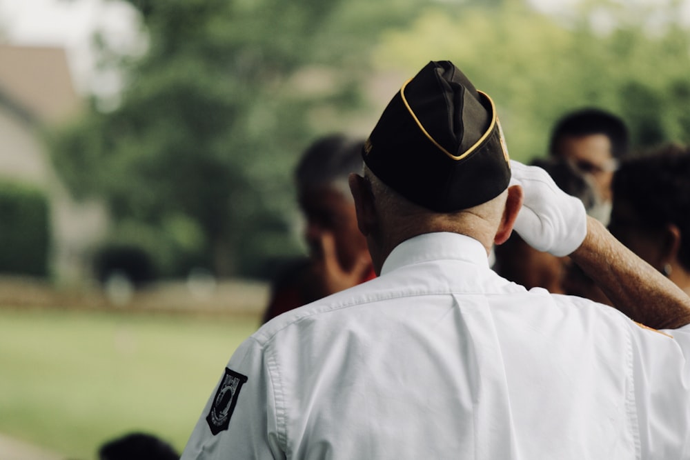 homme vêtu d’un uniforme blanc saluant